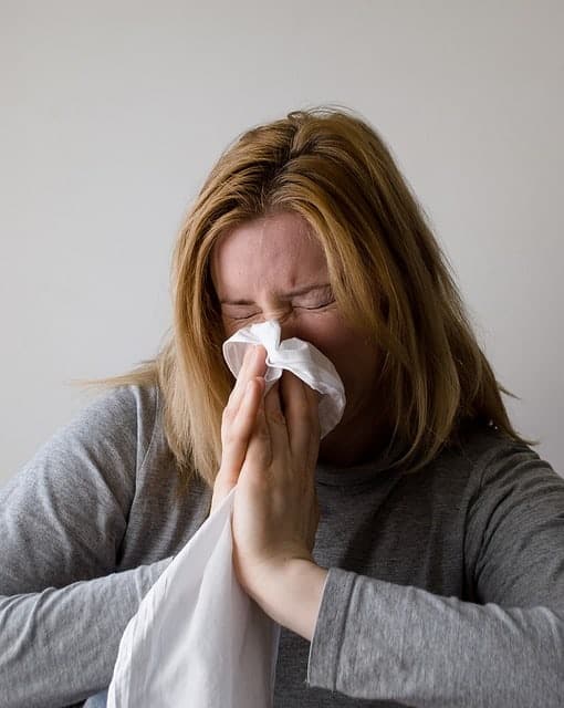 Woman sneezing because of allergy